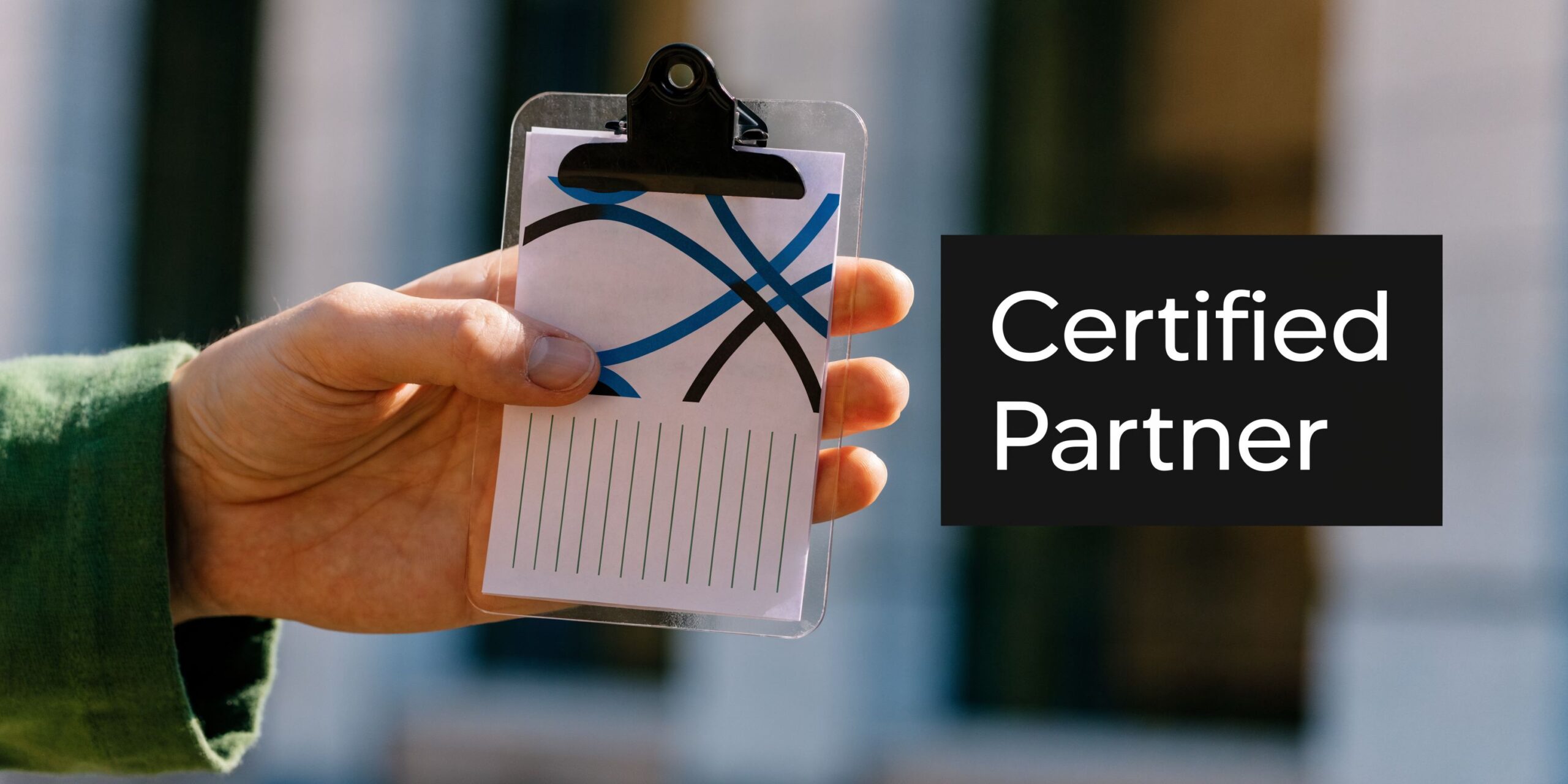 A hand holding a clear plastic clipboard with abstract blue and black lines and lined paper inside.