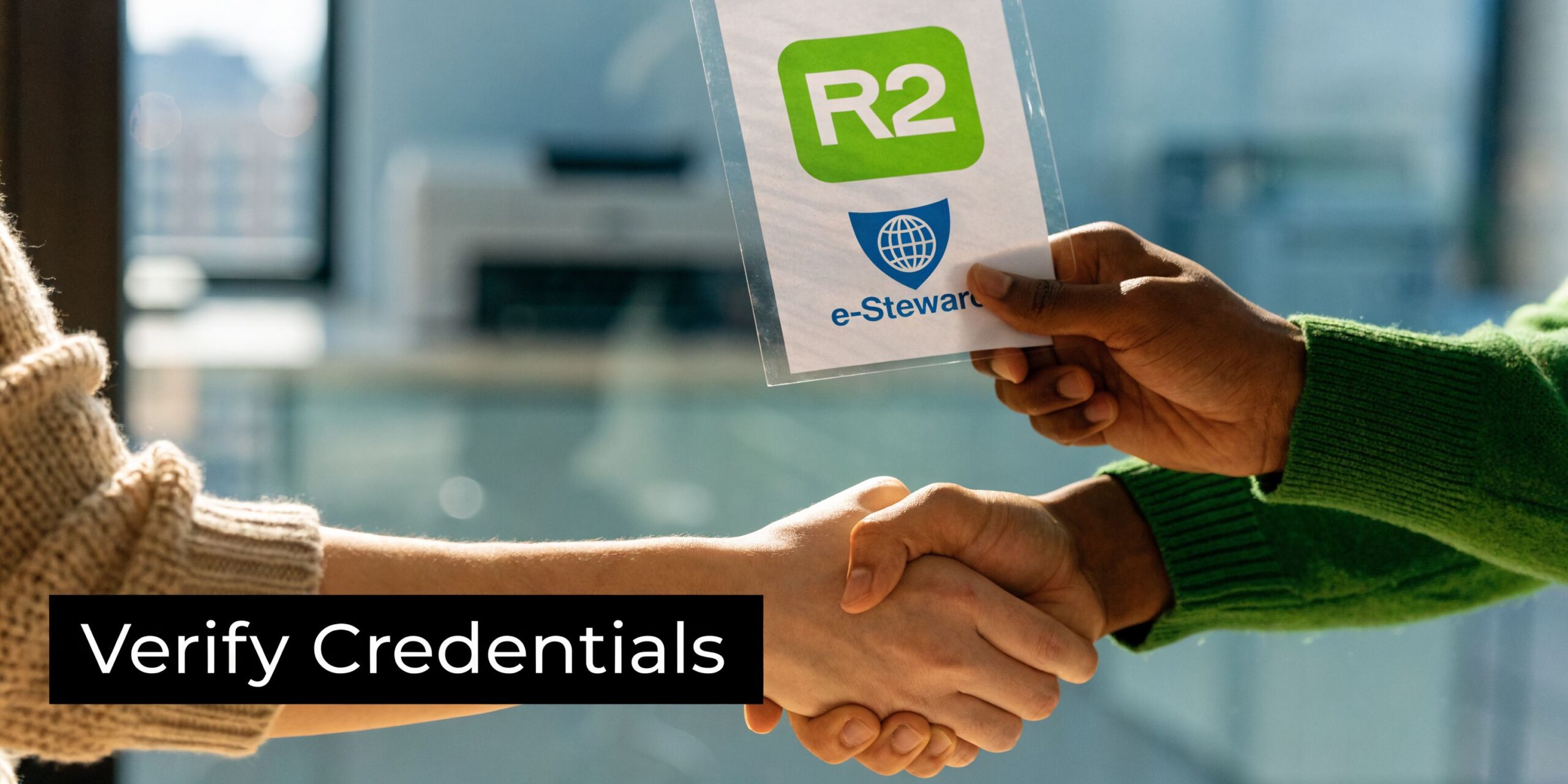 Two people shaking hands while holding a document displaying R2 and e-stewards recycling certification logos.